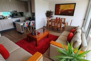 ein Wohnzimmer mit einem Sofa und einem Tisch in der Unterkunft Espectacular departamento Ñuñoa in Santiago
