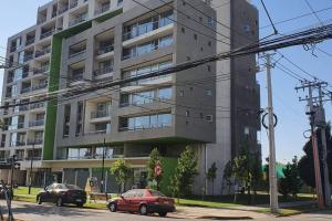 deux voitures garées devant un bâtiment dans l'établissement Espectacular departamento Ñuñoa, à Santiago