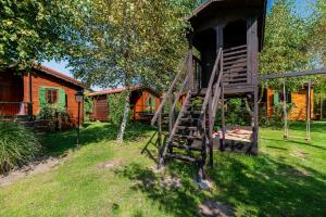 a wooden staircase leading up to a tree house at Domki Letniskowe Wiktoria in Dąbki