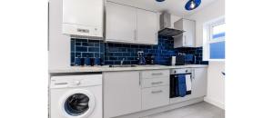 een witte keuken met een wasmachine en droger bij Comfortable and Stylish 1 BR flat - Sleeps 2 in Londen