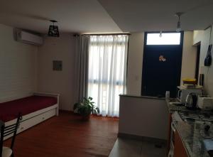 um quarto com uma cama e uma cozinha com uma janela em Munaska C em San Salvador de Jujuy