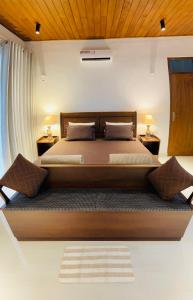 a bedroom with a large bed with two night stands at Rani Suite and Cabin in Kandy