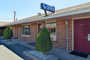 a office building with a red door and a sign on it at Americas Best Value Inn & Suites Klamath Falls in Klamath Falls