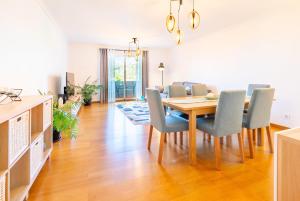 a dining room and living room with a table and chairs at Serene Haven Retreat - Madeira Island in Caniço
