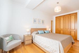 un dormitorio con una cama y una silla en Serene Haven Retreat - Madeira Island, en Caniço 5 fotos más