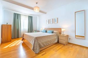 a bedroom with a bed and a mirror on the wall at Serene Haven Retreat - Madeira Island in Caniço