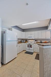 a large kitchen with white appliances and white cabinets at Crescent Beauty in Myrtle Beach