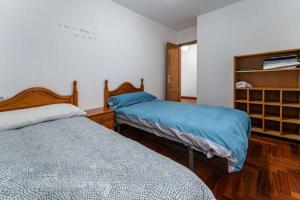 - une chambre avec 2 lits et une étagère dans l'établissement Good Stay Lugo Apartment, à Lugo