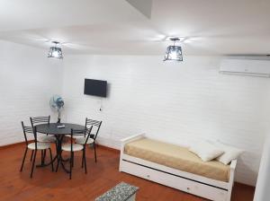 um quarto com uma cama e uma mesa com cadeiras em Munaska C em San Salvador de Jujuy