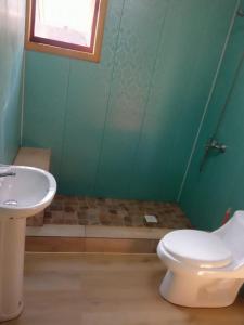 a bathroom with a toilet and a sink at Casa Los Queñes in Navidad