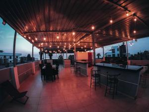 a rooftop patio with tables and chairs and lights at Hospedaje Rocio del Mar in Cerro Azul