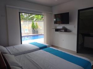 a bedroom with a large bed and a swimming pool at Quinta Villateo in Villavicencio