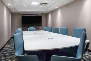a conference room with a table and chairs and a screen at Wingate By Wyndham - Orlando International Airport- Free Hot Breakfast in Orlando +31 photos