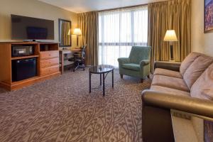 een woonkamer met een bank en een bureau in een hotelkamer bij Drury Inn & Suites Atlanta Airport in Atlanta