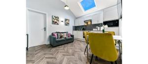 a living room with a table and yellow chairs at Cozy 1 BD Flat in London! in Romford
