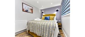 a bedroom with a bed with a yellow headboard at Newly Renovated 1BD Flat Perfect for Travellers in Romford
