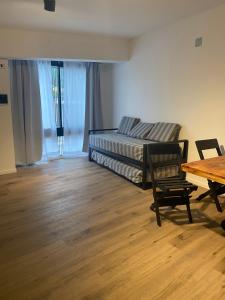 巴拉那Departamentos Av. Ramírez的客厅配有床和木桌