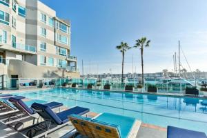 einen Pool mit Liegestühlen und ein Gebäude in der Unterkunft Skyline Oasis: Luxe 3-Floor Waterfront Penthouse in Los Angeles