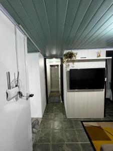 einen Flur mit einer Decke und einem großen TV in der Unterkunft Minha casa in Navegantes