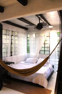 uma cama de rede num quarto com janelas em REFUGIO DO SAGRADO MORERE em Cairu