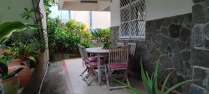 a patio with a table and chairs and plants at casahibiscus in Fort-de-France