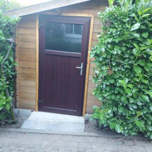 a burgundy door of a small house with at Schöne voll ausgestattete Ferienwohnung in Havixbeck