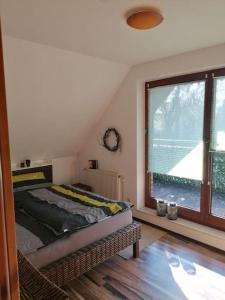 a bedroom with a bed and a large window at Schöne voll ausgestattete Ferienwohnung in Havixbeck