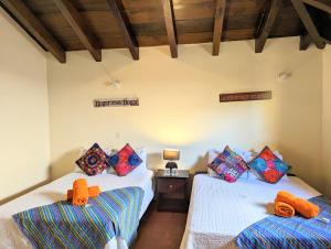 a bedroom with two beds with orange towels on them at Casa Quetzalli, La Merced in Antigua Guatemala
