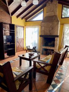 sala de estar con mesa y chimenea de piedra en Casa Crisantemos en Costa del Este