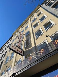 ein hohes Gebäude mit Schild für ein Hotel in der Unterkunft Palm Premium Hotel & Apartments in Düsseldorf