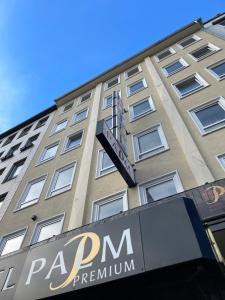 a tall building with a sign in front of it at Palm Premium Hotel & Apartments in Düsseldorf