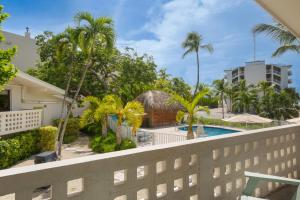 a balcony with a swimming pool and palm trees at Hadley Resort and Marina in Islamorada