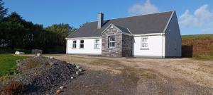 a white house with a black roof at Harbor View in Valentia Island