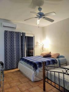 a bedroom with a bed and a ceiling fan at Lot # 7 ~ Large, Energetic Baja House in Guaymas