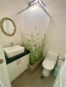 ein Badezimmer mit einem WC, einem Waschbecken und einem Spiegel in der Unterkunft Acogedora Casa cerca a la playa in Pisco