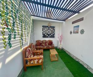 ein Wohnzimmer mit einem Sofa und einem Tisch in der Unterkunft Acogedora Casa cerca a la playa in Pisco
