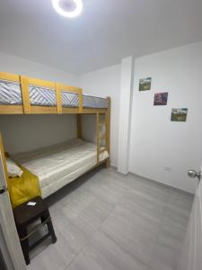 Zimmer mit 2 Etagenbetten und einer Tür in der Unterkunft Acogedora Casa cerca a la playa in Pisco