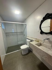 W łazience znajduje się toaleta, umywalka i lustro. w obiekcie Chalé Pé do Morro w mieście Penha