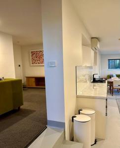 a room with two toilets in a room with a kitchen at Stylish Sandy Bay Apartment in Sandy Bay