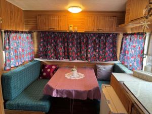 a small dining room with a table in an rv at BERTHA caravan River Heads in River Heads +7 photos
