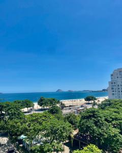 - une vue sur la plage avec des arbres et l'océan dans l'établissement Loft Praia de Copacabana, à Rio de Janeiro