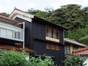 una casa negra con una montaña en el fondo en RITA Izumo Sagiura, en Izumo