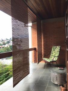 een afgeschermde veranda met een stoel en een tafel bij Studio Carini in Curitiba