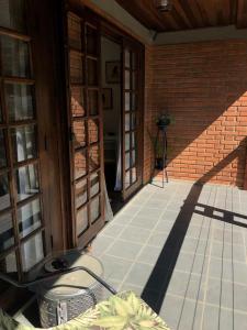 een veranda van een huis met een stenen muur bij Studio Carini in Curitiba
