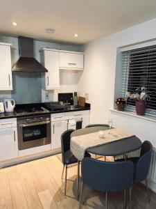 a kitchen with a table and chairs and a stove at Guest House Nikol in Sherborne Saint John
