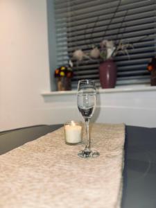 una candela e un bicchiere di vino seduti su un tavolo di Guest House Nikol a Sherborne Saint John