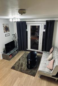 uma sala de estar com um sofá e uma televisão em Guest House Nikol em Sherborne Saint John