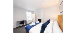 Un dormitorio con una cama con almohadas azules y blancas. en Hassle-Free & Handsome Brand-New 3-Bed Home, en Mánchester