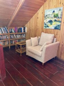 uma sala de estar com uma cadeira e estantes em La Cabaña: Descanso y Naturaleza em Cartago