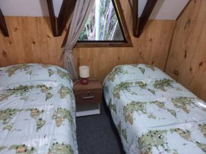 Schlafzimmer mit einem Bett und einem Fenster in der Unterkunft Donde Coco in Quellón